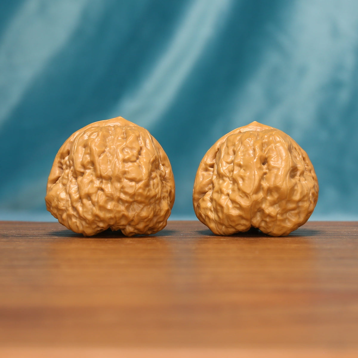 The Azure Rosette L38 wenwan walnut pair showing detailed floral ridge patterns
