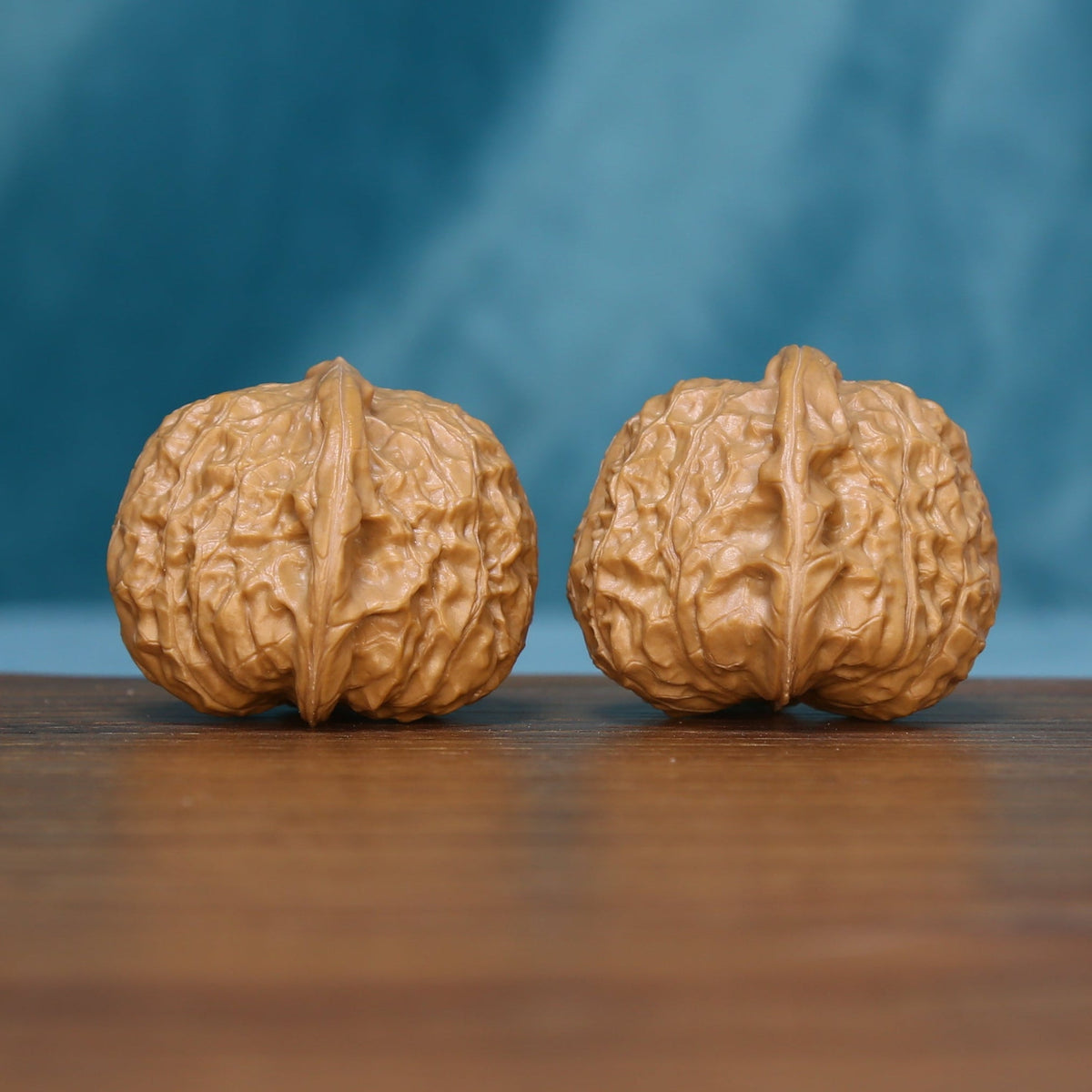 Front view of two 6105 wenwan walnuts with raised branching ridges
