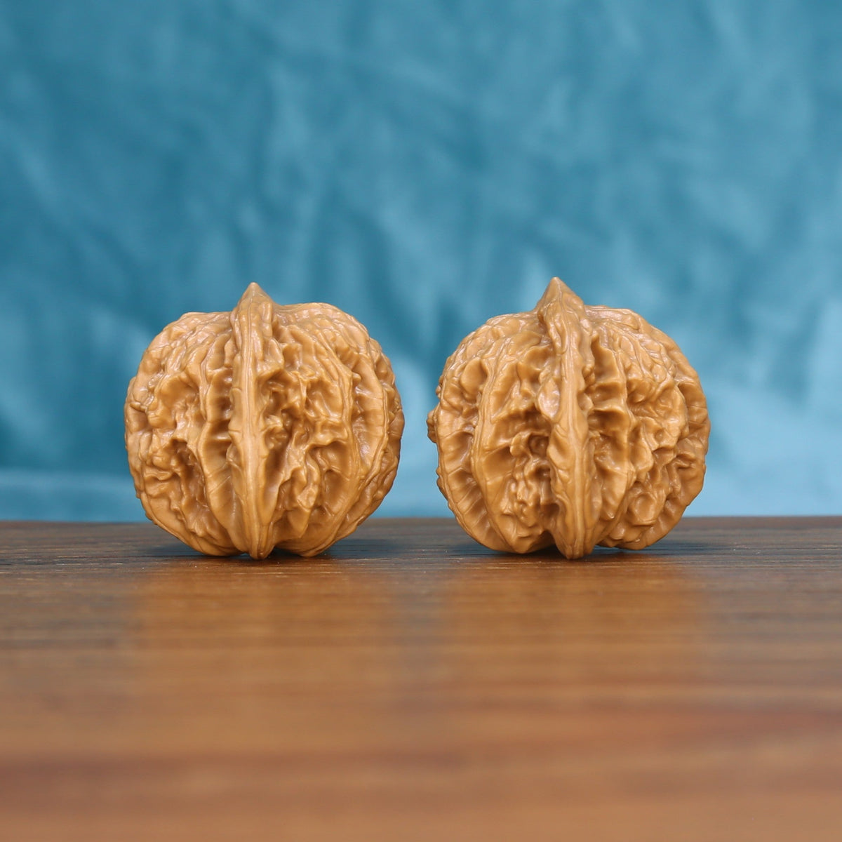 Close view of two matched Coiling Dragon wenwan walnuts showing deep ridge carving and natural grain
