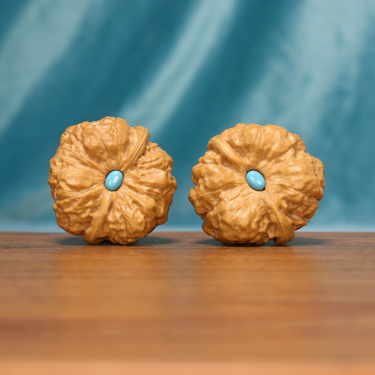 The Azure Rosette L38 wenwan walnut pair, front view with blue-toned centers
