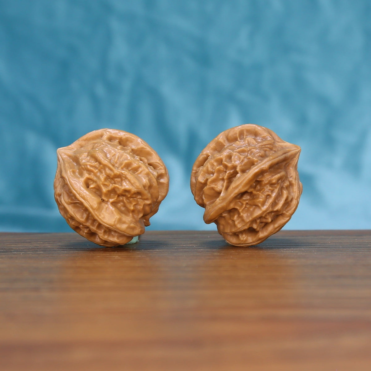 Three-quarter view of a Four-Ridge Wenwan walnut pair on a wooden surface
