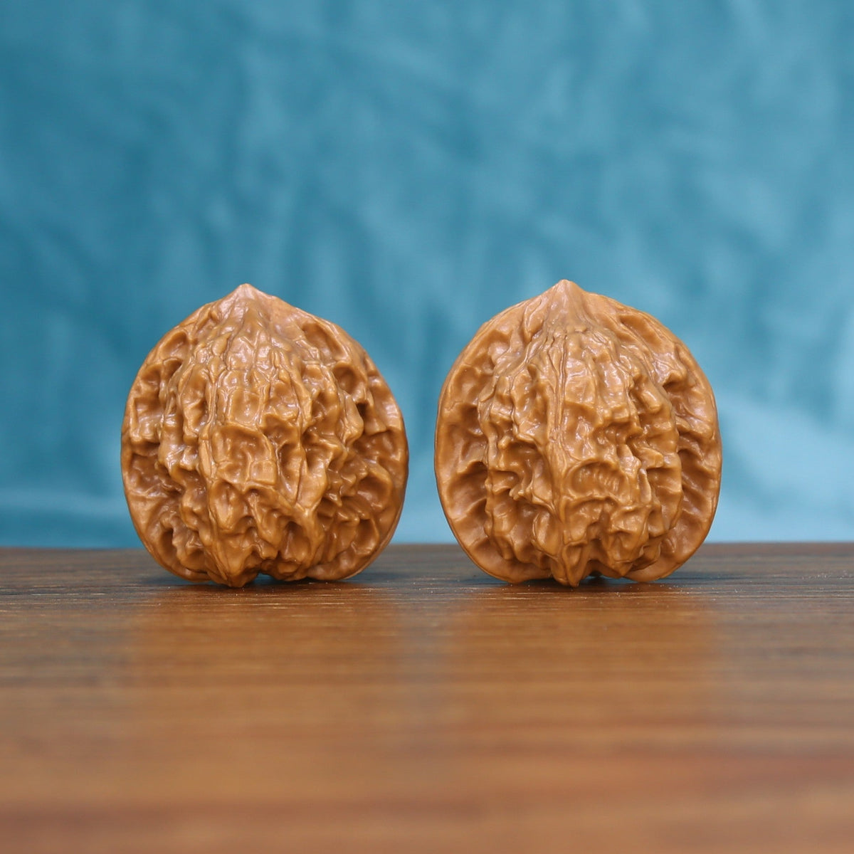 Front view of a matched pair of Linglong Wenwan walnuts on a wooden surface
