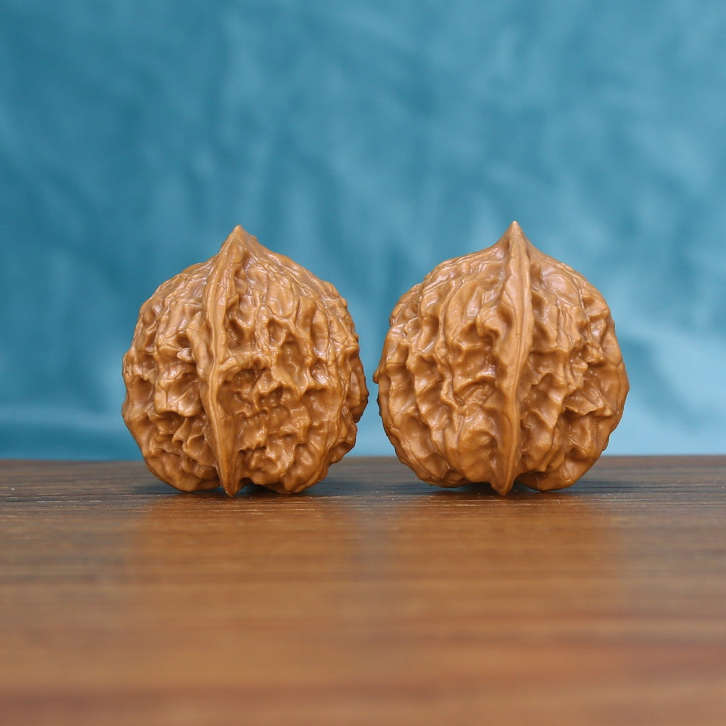 Three-quarter view of two Linglong Wenwan walnuts showing their natural textured shells
