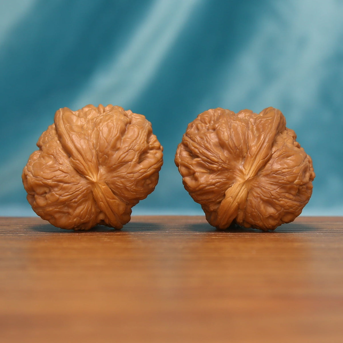 L24 Wenwan walnut pair shown from the opposite side, highlighting the natural surface patterns and radiating ridges.
