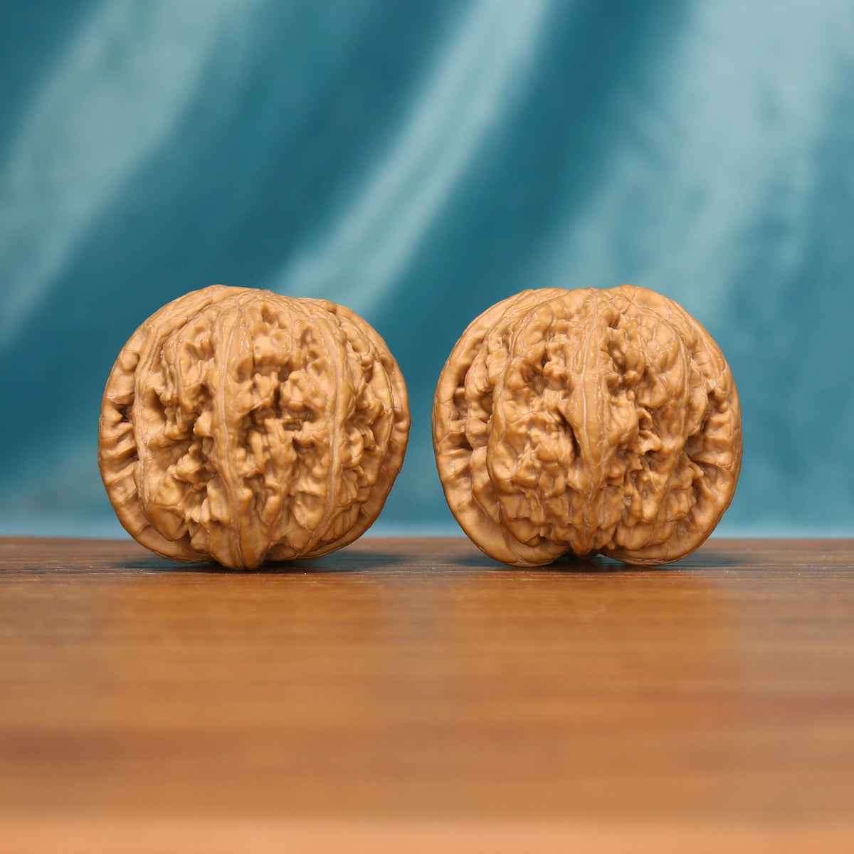 Front view of The Twin Peaks Wenwan Walnut Set with two broad rounded walnuts and dense natural ridges.
