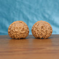 Two Gong-Deng wenwan walnuts on wooden surface, blue fabric background – matching imperial set
