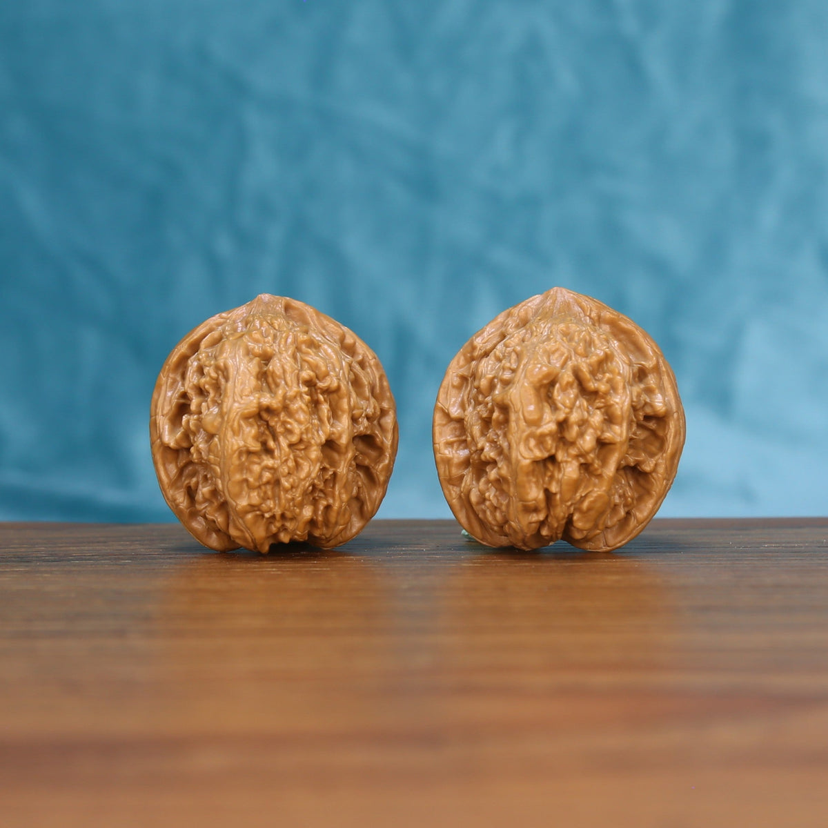 Front view of a matched pair of Stone Wenwan walnuts showing natural shell texture
