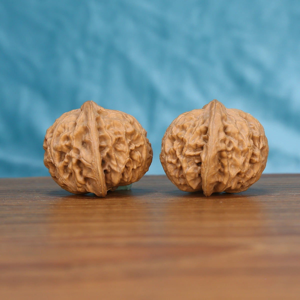 Gong-Deng walnut pair bottom view on wooden surface, natural lantern shape and texture detail