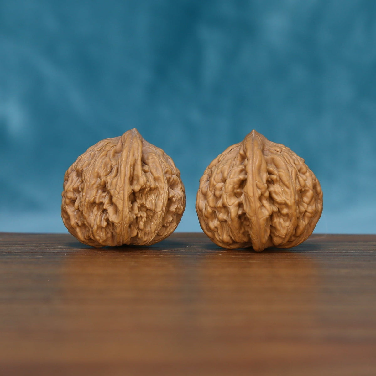 Detailed side view of The Ivory Rounds Wenwan walnuts with symmetrical textured surfaces and natural variation.
