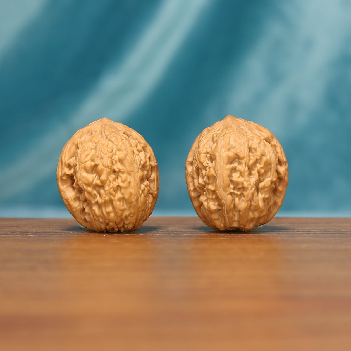 Front view of The Pocket Pebbles Wenwan Walnut Set with two compact rounded walnuts and detailed natural ridges.
