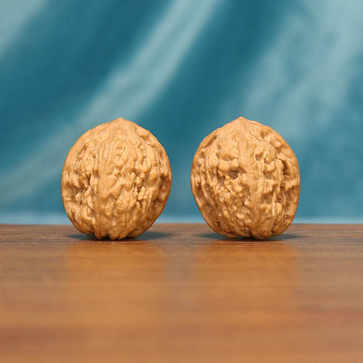 Angled front view of The Pocket Pebbles Wenwan walnuts showing their small size and warm natural color.
