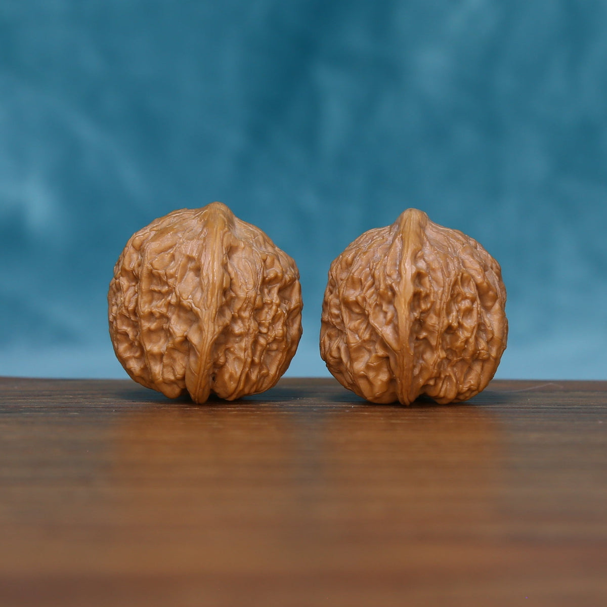 Detailed side view of The Stone Pearls Wenwan walnuts with symmetrical textured surfaces and natural variation.
