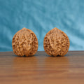 Two Ling-Long wenwan walnuts on wooden surface, blue fabric background – matching exquisite enigma set