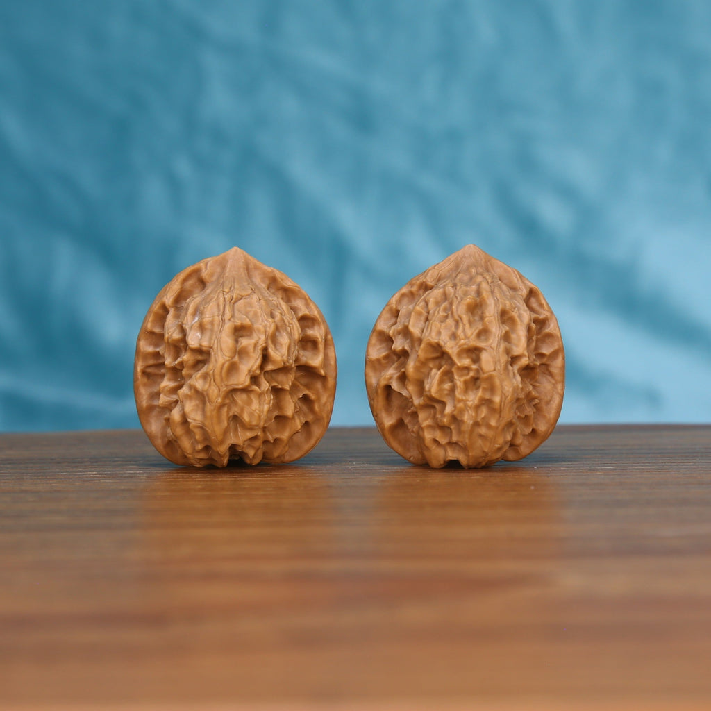  Ling-Long walnut set side profile on wood, blue background – deep hollow-carved enigma grain detail