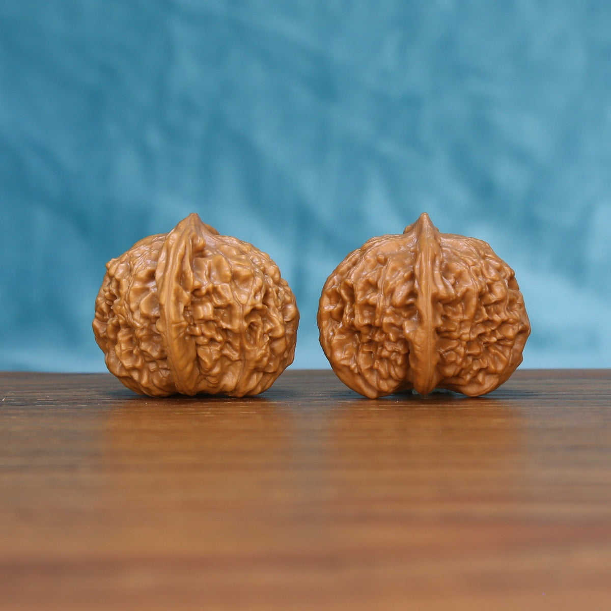 Side view of two Qinhuangdao Yuanbao Wenwan walnuts showing their compact rounded profile
