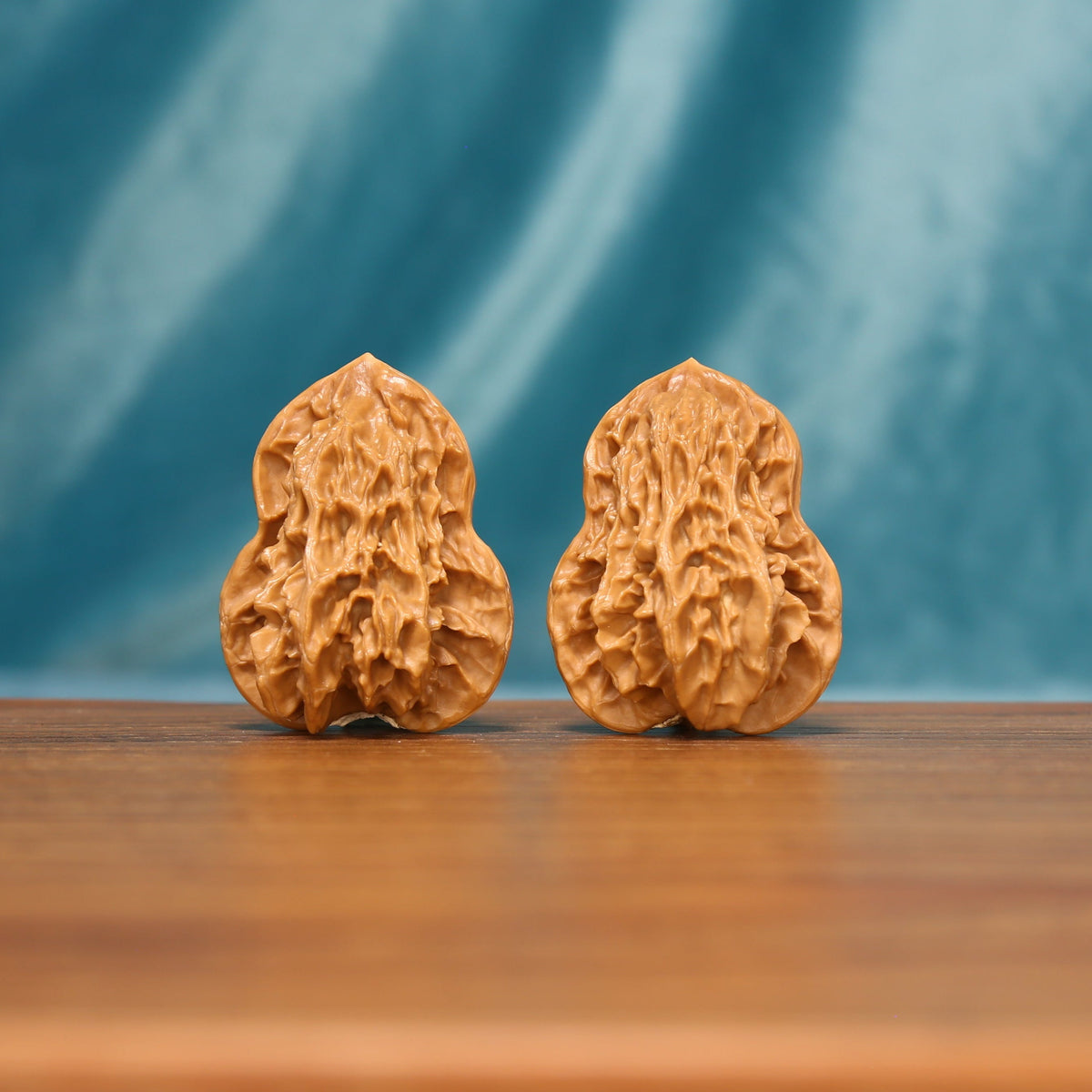 L18 Wenwan walnut matched pair displayed side by side on a wooden surface against a teal background.
