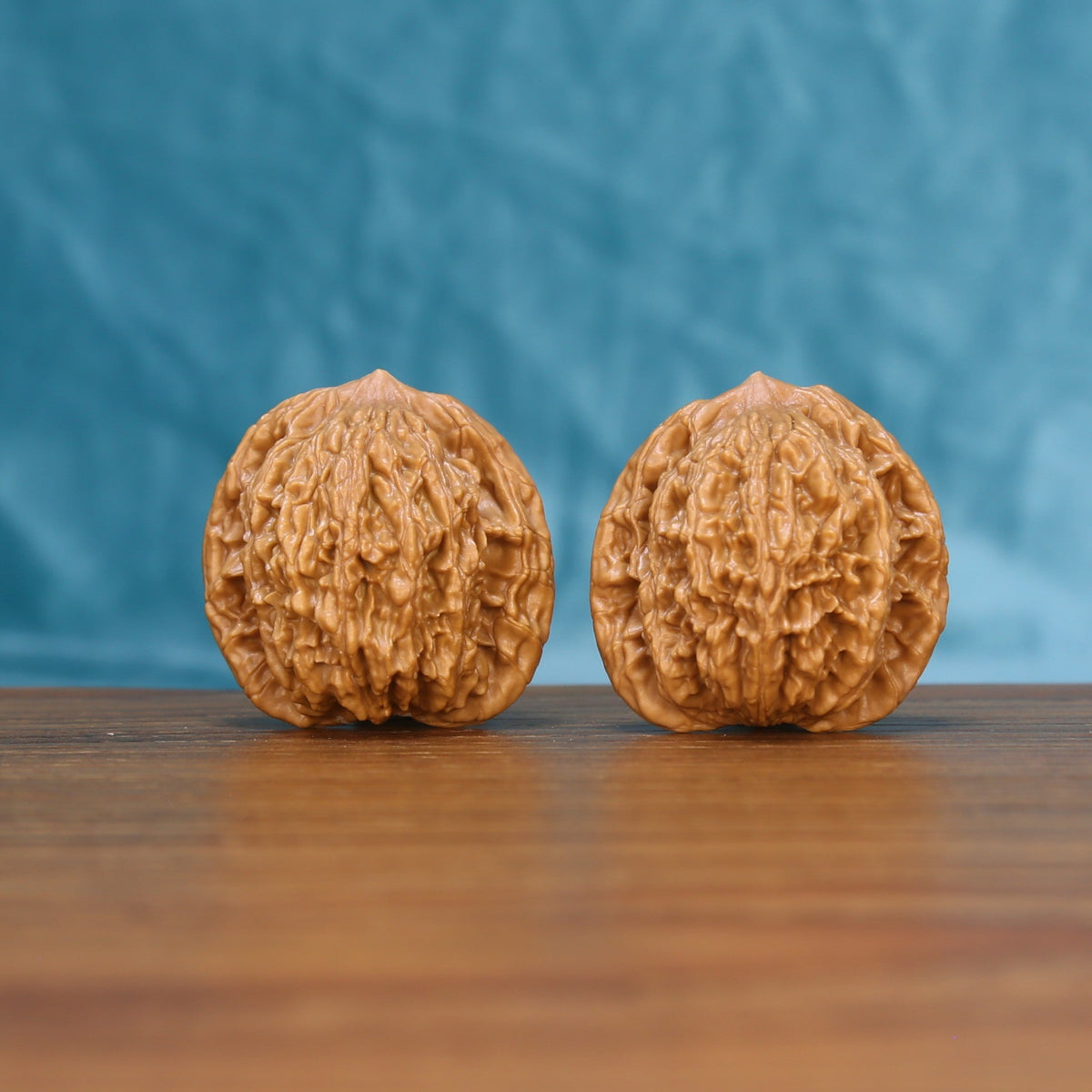 Front view of a matched pair of Wheat Tiger Wenwan walnuts with bold natural ridges
