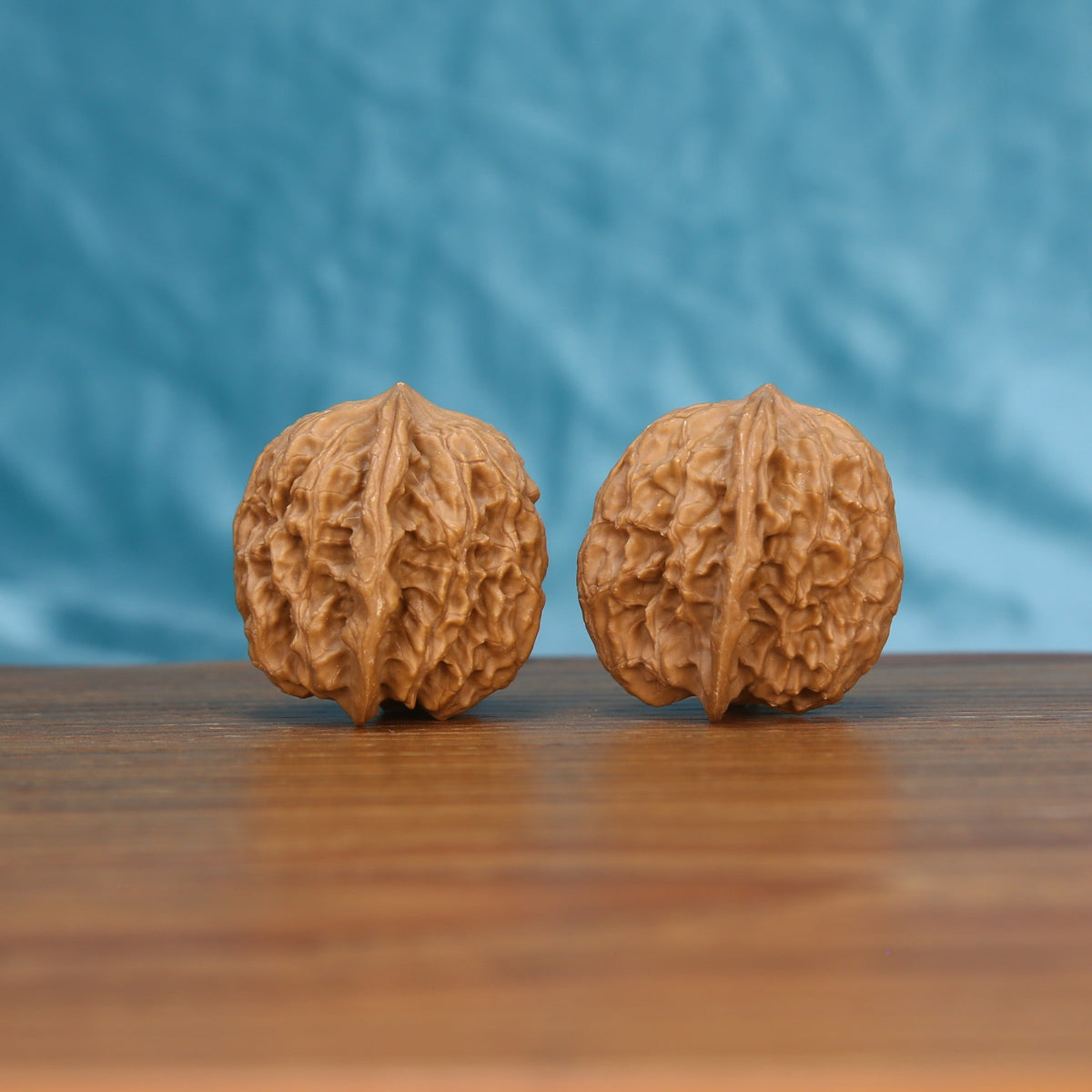 Chang-Men wenwan walnut pair alternate angle, blue background – symmetrical natural texture
