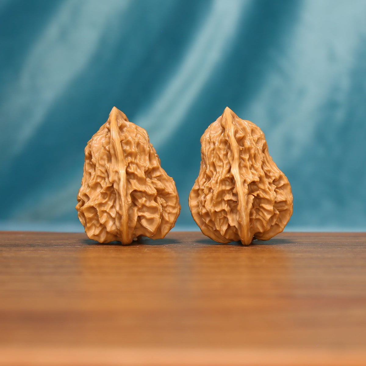 L18 Wenwan walnut matched pair shown from a detailed front angle, displaying elongated forms and dense textured ridges.
