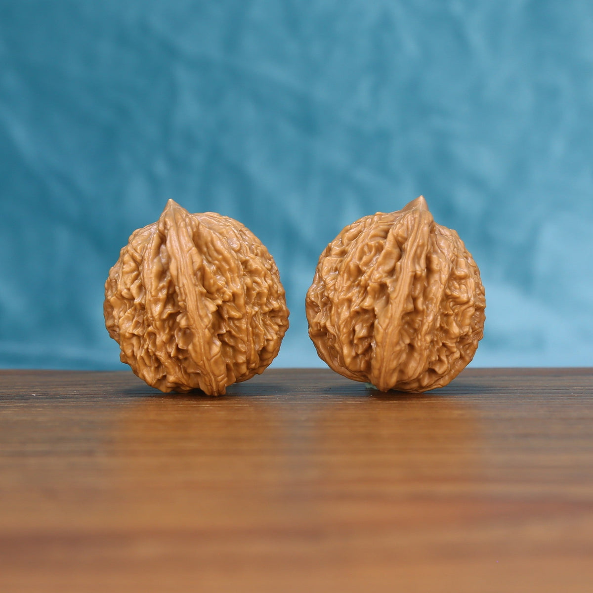 Three-quarter view of two Wheat Tiger Wenwan walnuts showing textured shells
