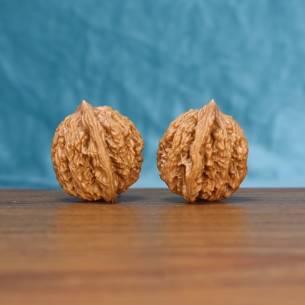 Side view of a Wheat Tiger Wenwan walnut pair on a wooden surface
