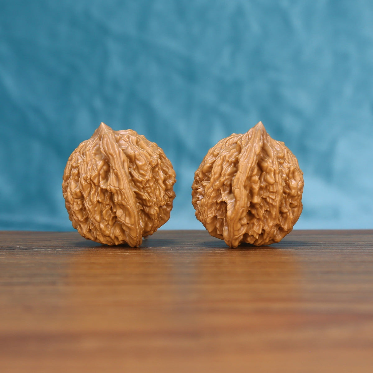 Side view of a Wheat Tiger Wenwan walnut pair on a wooden surface
