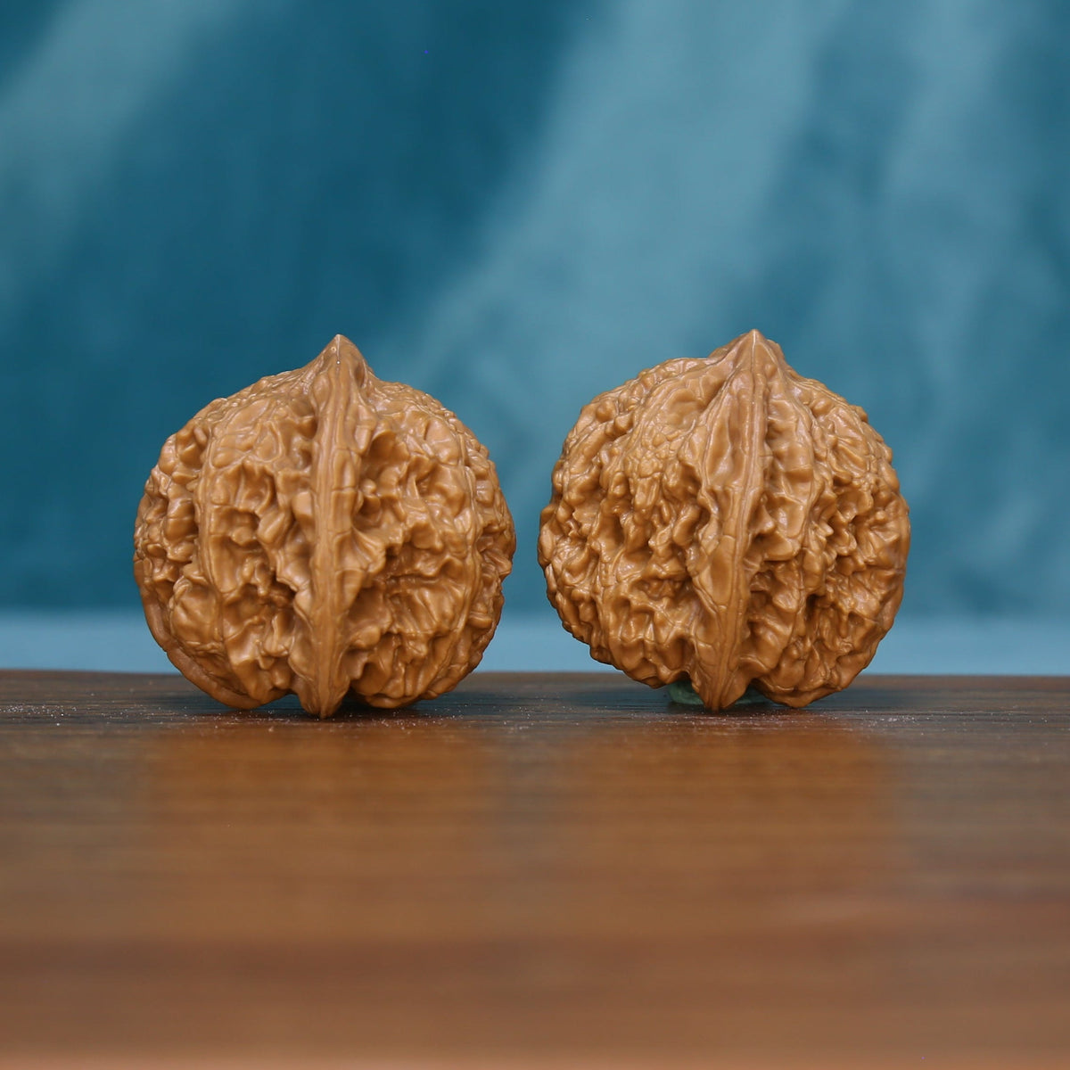 Front view of two 6180 Braided Crest wenwan walnuts with branching grooves
