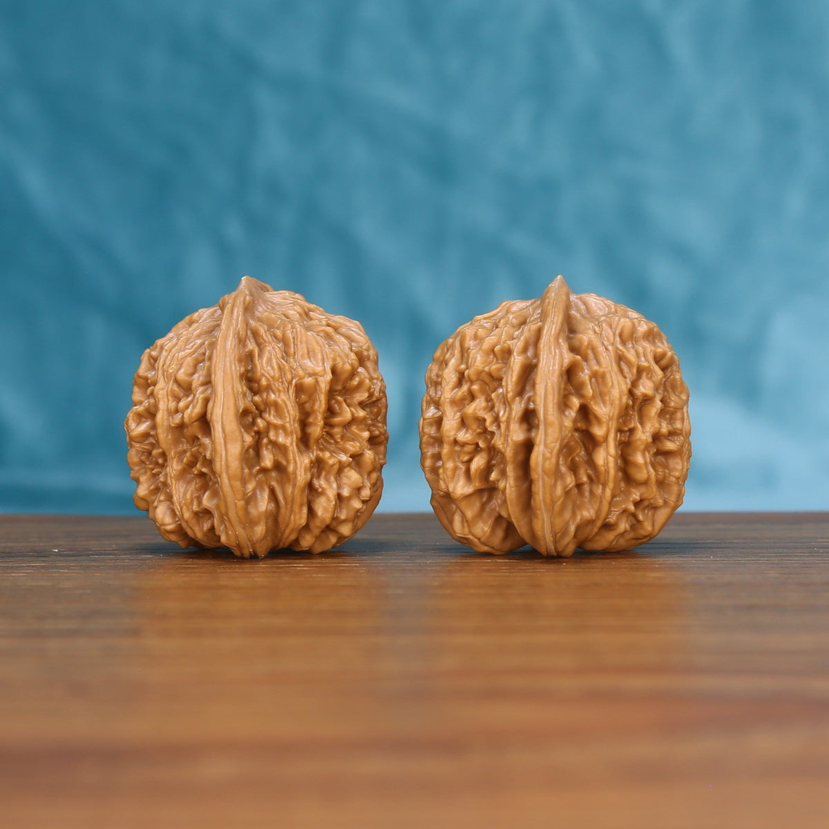 Three-quarter view of two Sizuo Lou Wenwan walnuts showing detailed shell texture
