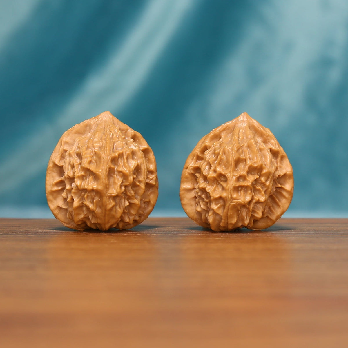 Front view of The Crowned Rounds Wenwan Walnut Set with two rounded walnuts covered in intricate natural ridges.
