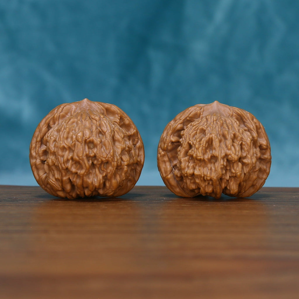Side view of The Bronze Relics Wenwan Walnut Set showing the walnuts’ dense ridge patterns and sculpted profiles.
