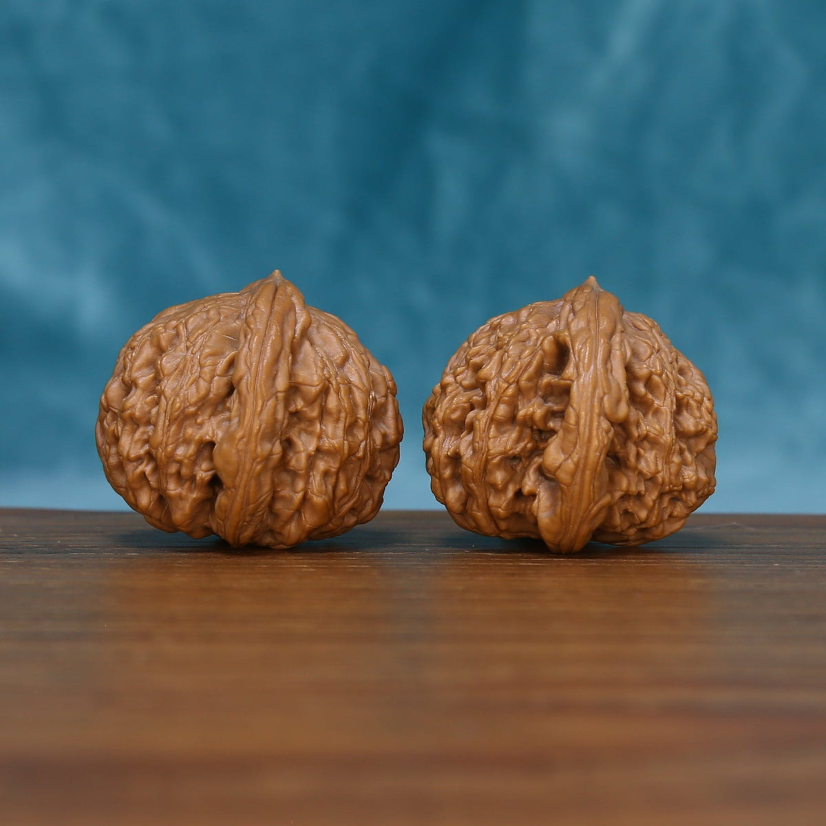 Detailed side view of The Bronze Relics Wenwan walnuts with pronounced vertical ridges and natural variation.
