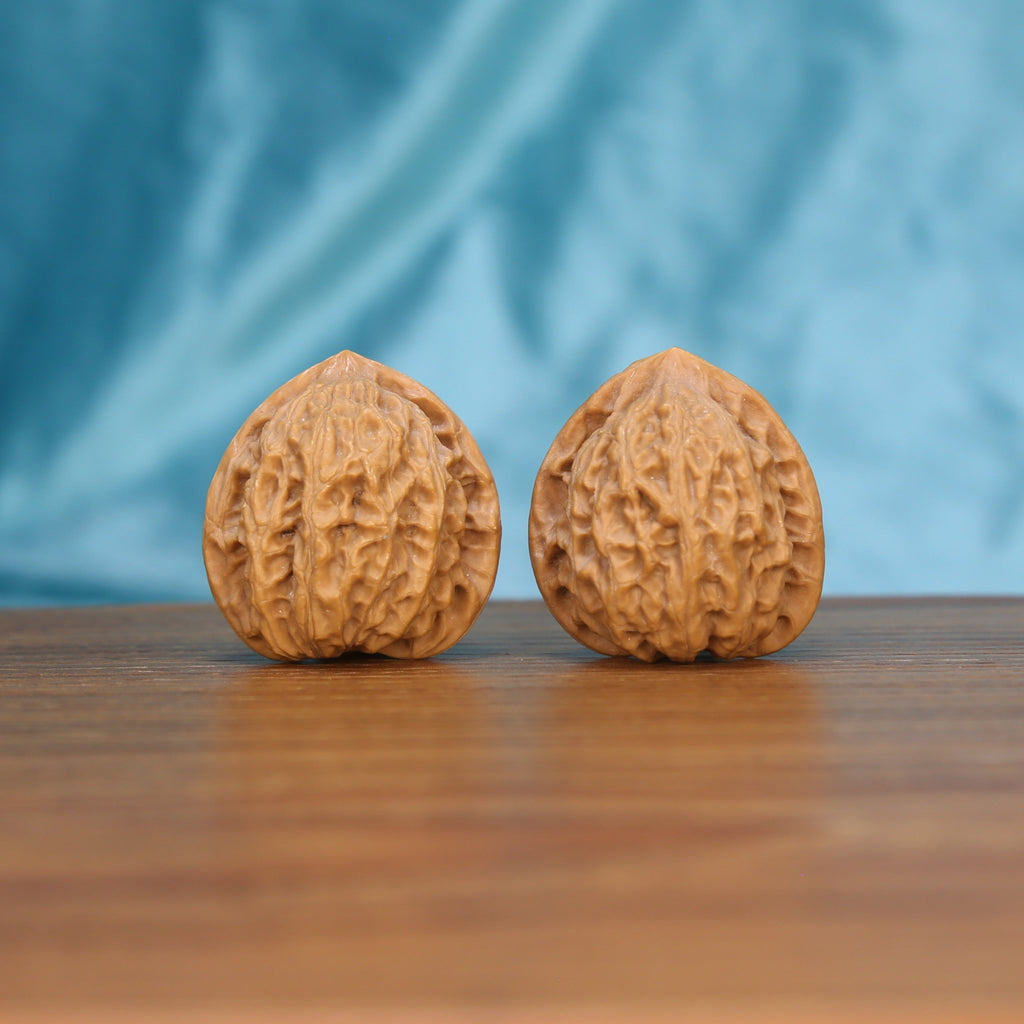 Xiao-Jin-Niu walnut set side profile on wood, blue background – golden bull grain detail