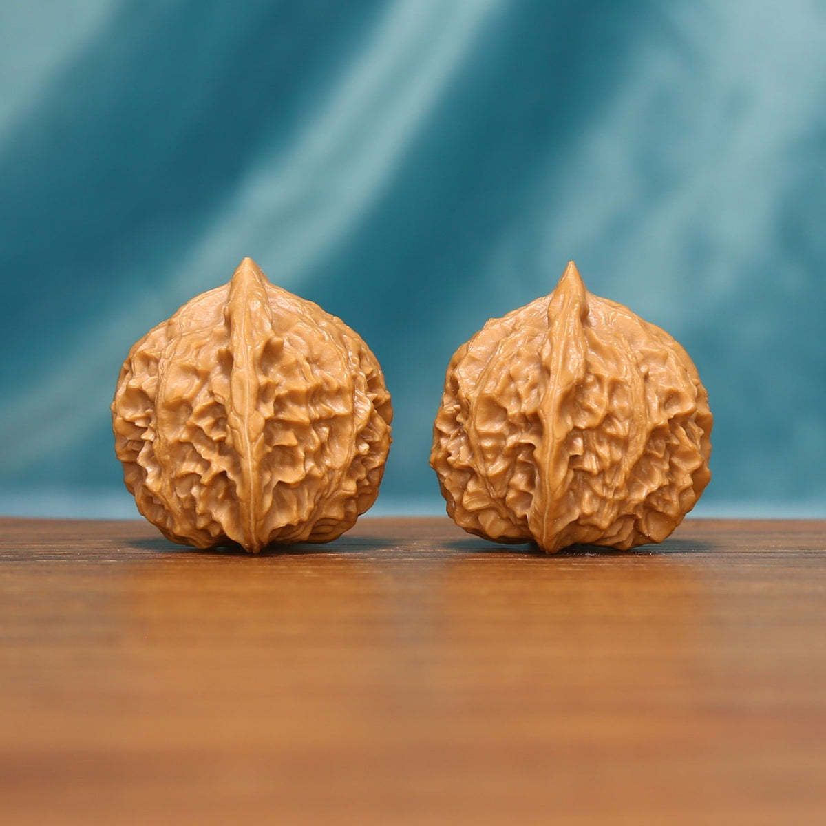 Side view of The Crowned Rounds Wenwan Walnut Set highlighting the walnuts’ crown-like ridge patterns.
