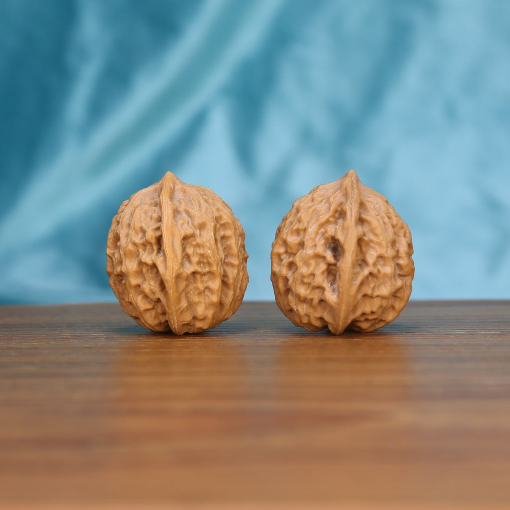 Single Xiao-Jin-Niu wenwan walnut on wooden surface, blue background – intricate golden bull natural texture