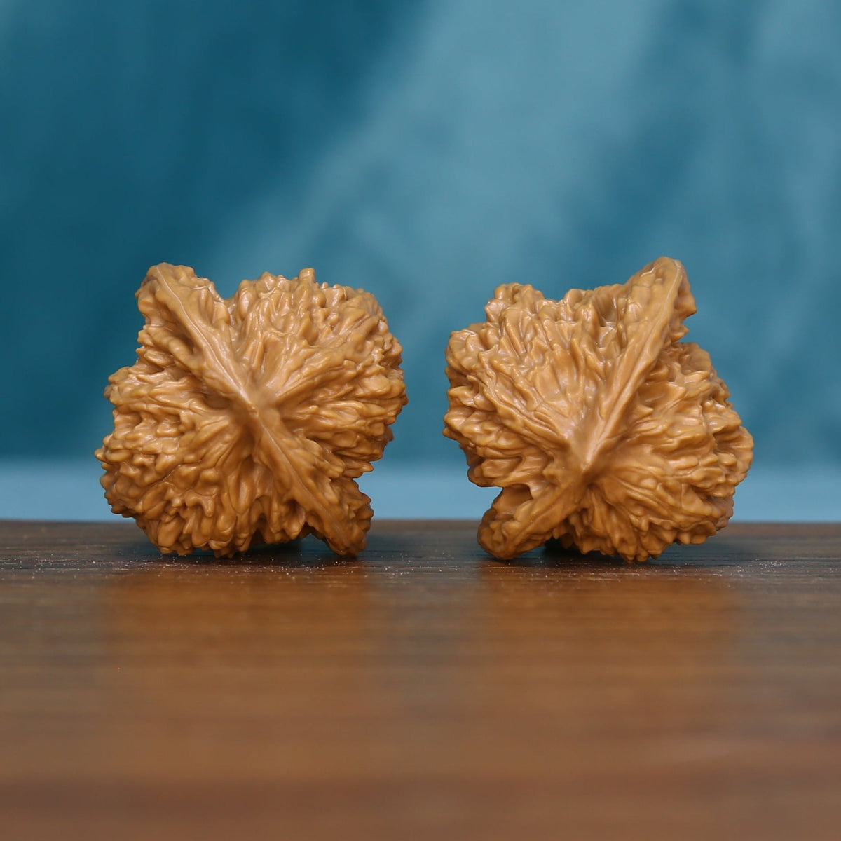 Side view of two 6157 Deep Furrow wenwan walnuts showing their sculptural grooves
