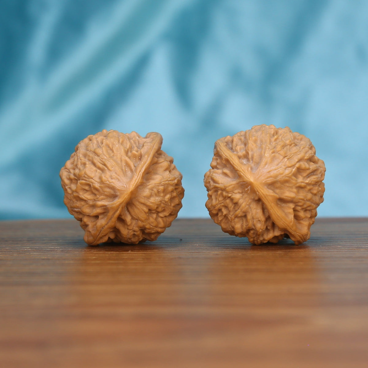 Single Xiao-Jin-Niu wenwan walnut bottom view on wooden surface – natural base and golden bull texture detail