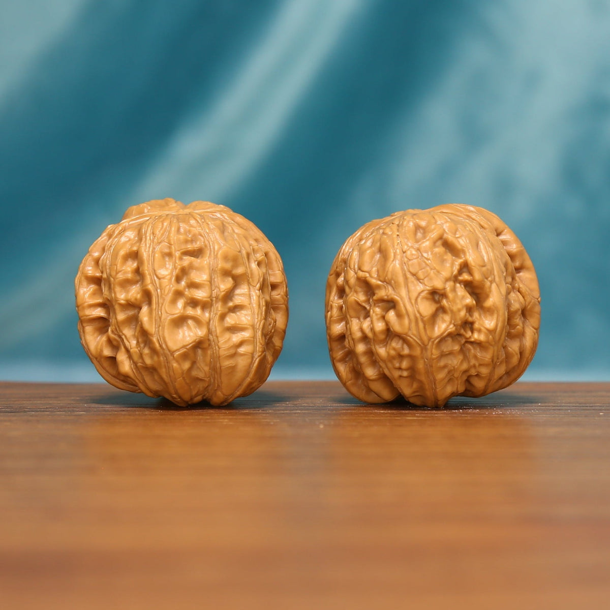 L21 Wenwan walnut matched pair displayed side by side on a wooden surface against a teal background.

