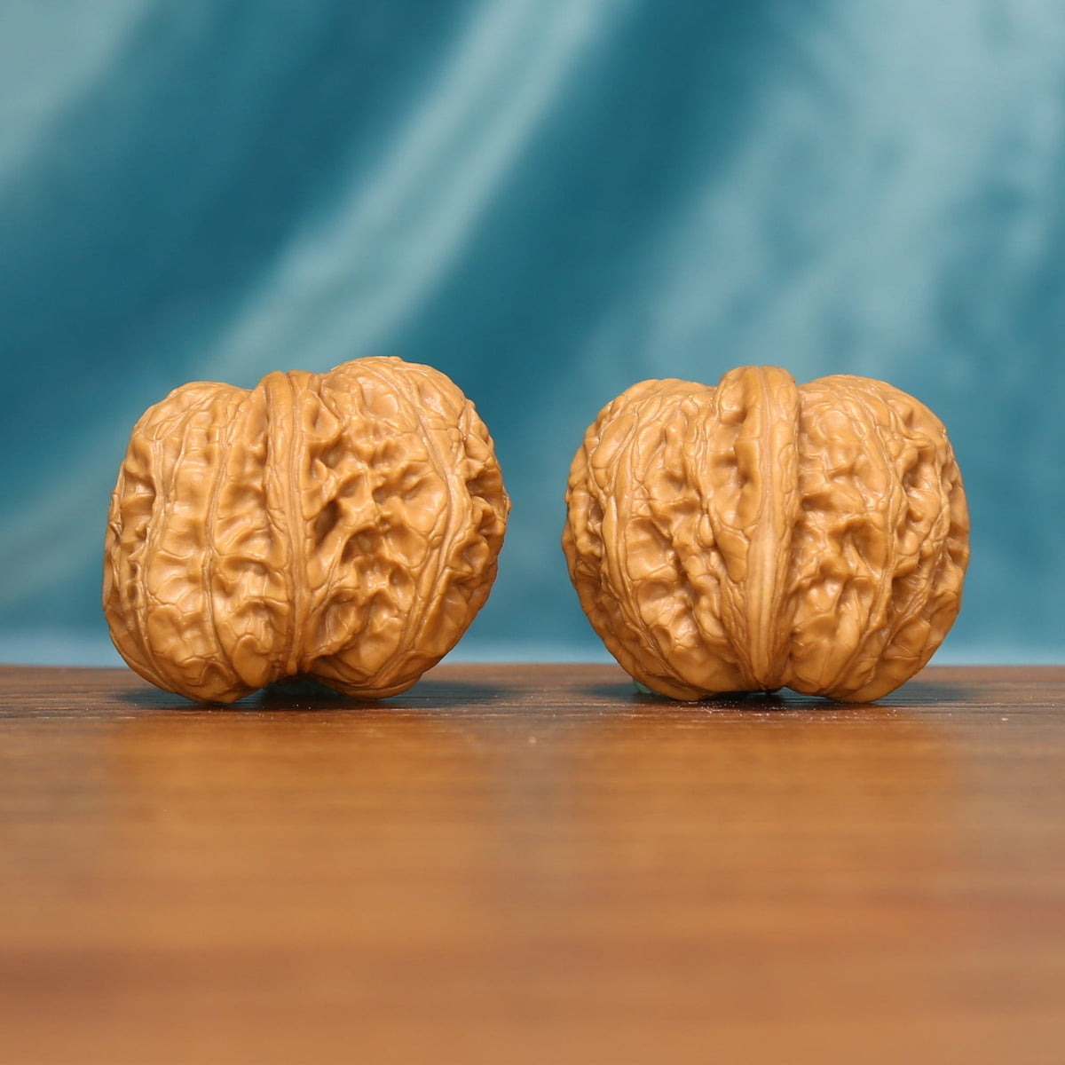 L21 Wenwan walnut matched pair shown from a close frontal angle, displaying detailed ridges and textured shells.
