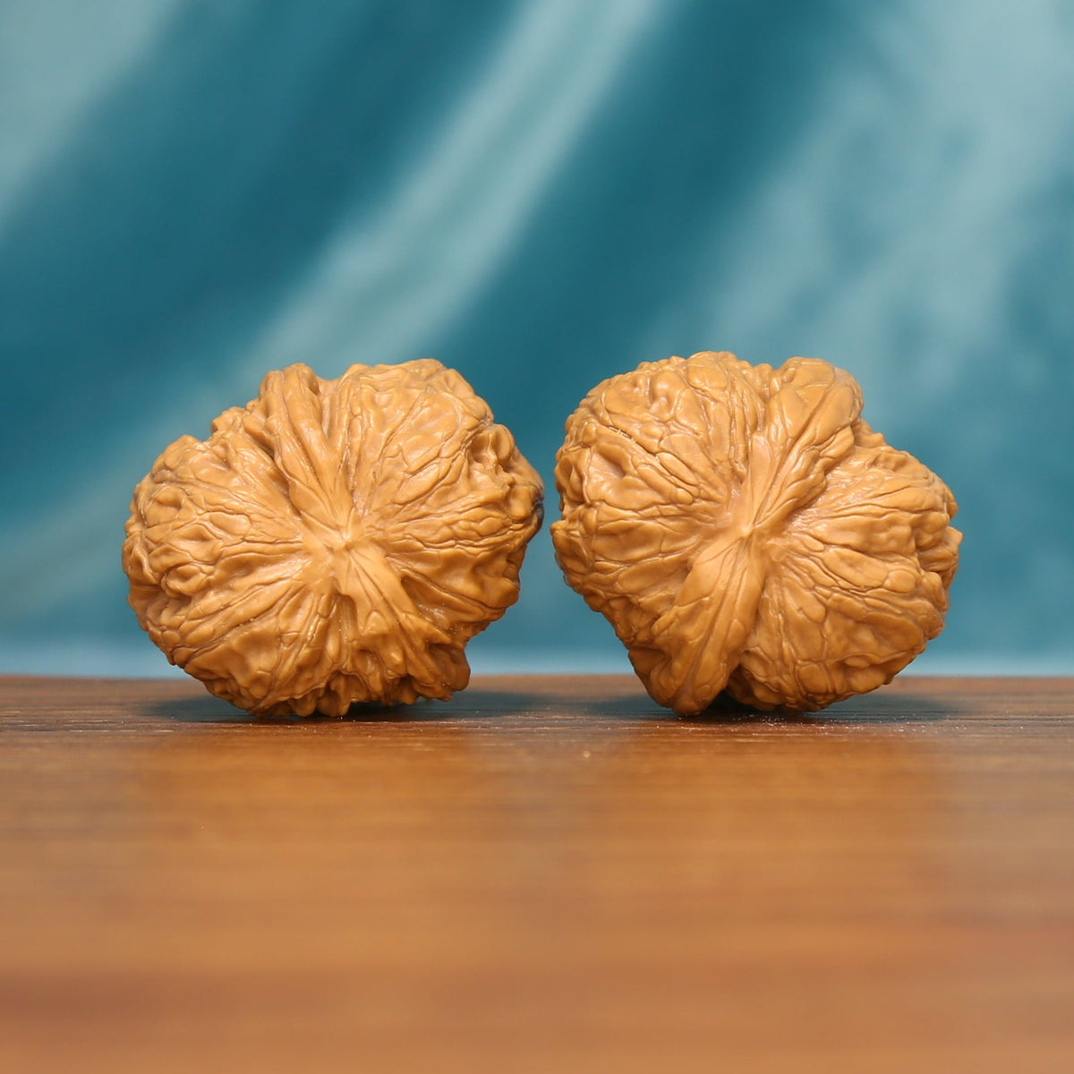 L21 Wenwan walnut pair shown from the side, highlighting radiating ridges and sculpted shell texture.
