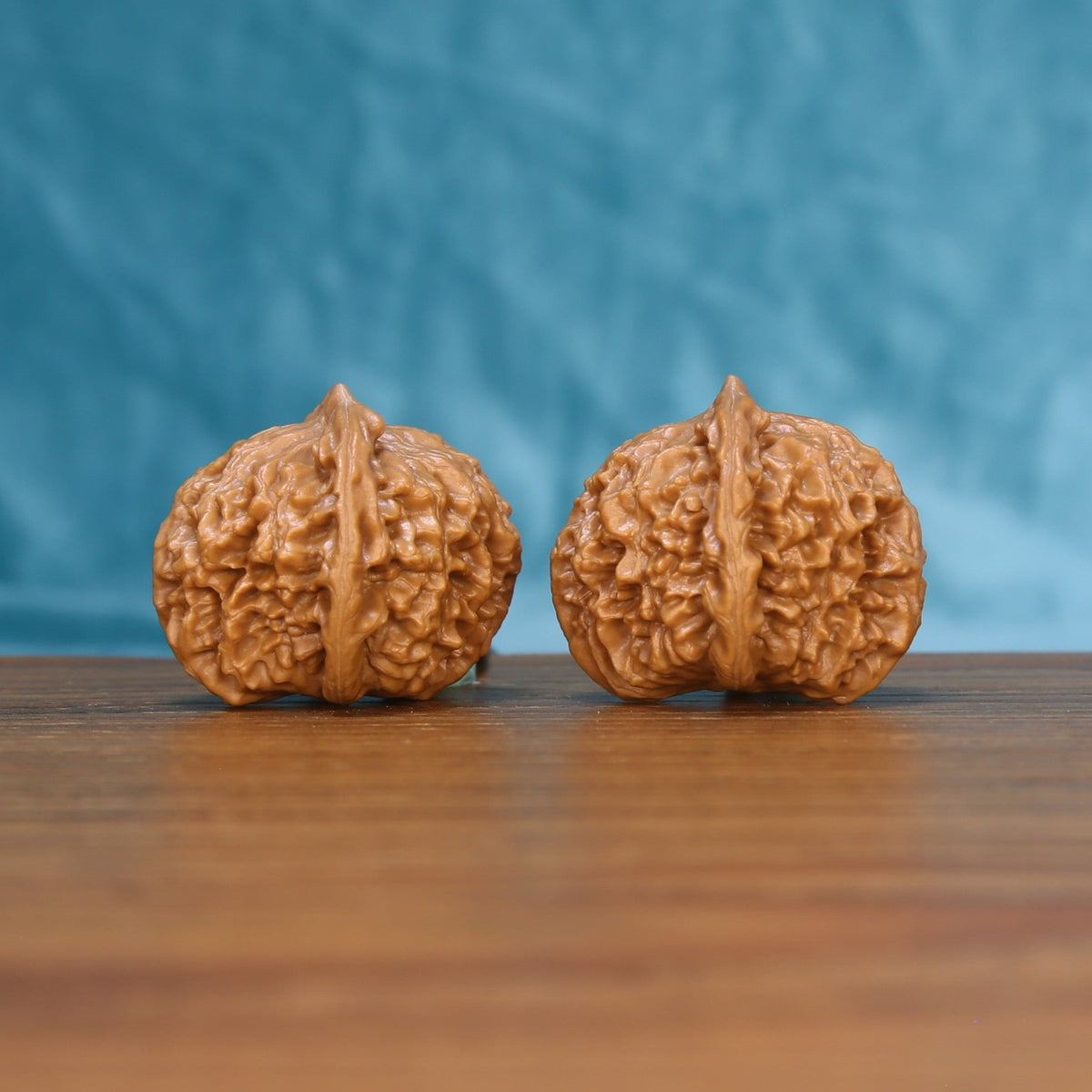 Three-quarter view of two Qinhuangdao Yuanbao Wenwan walnuts showing detailed natural ridges
