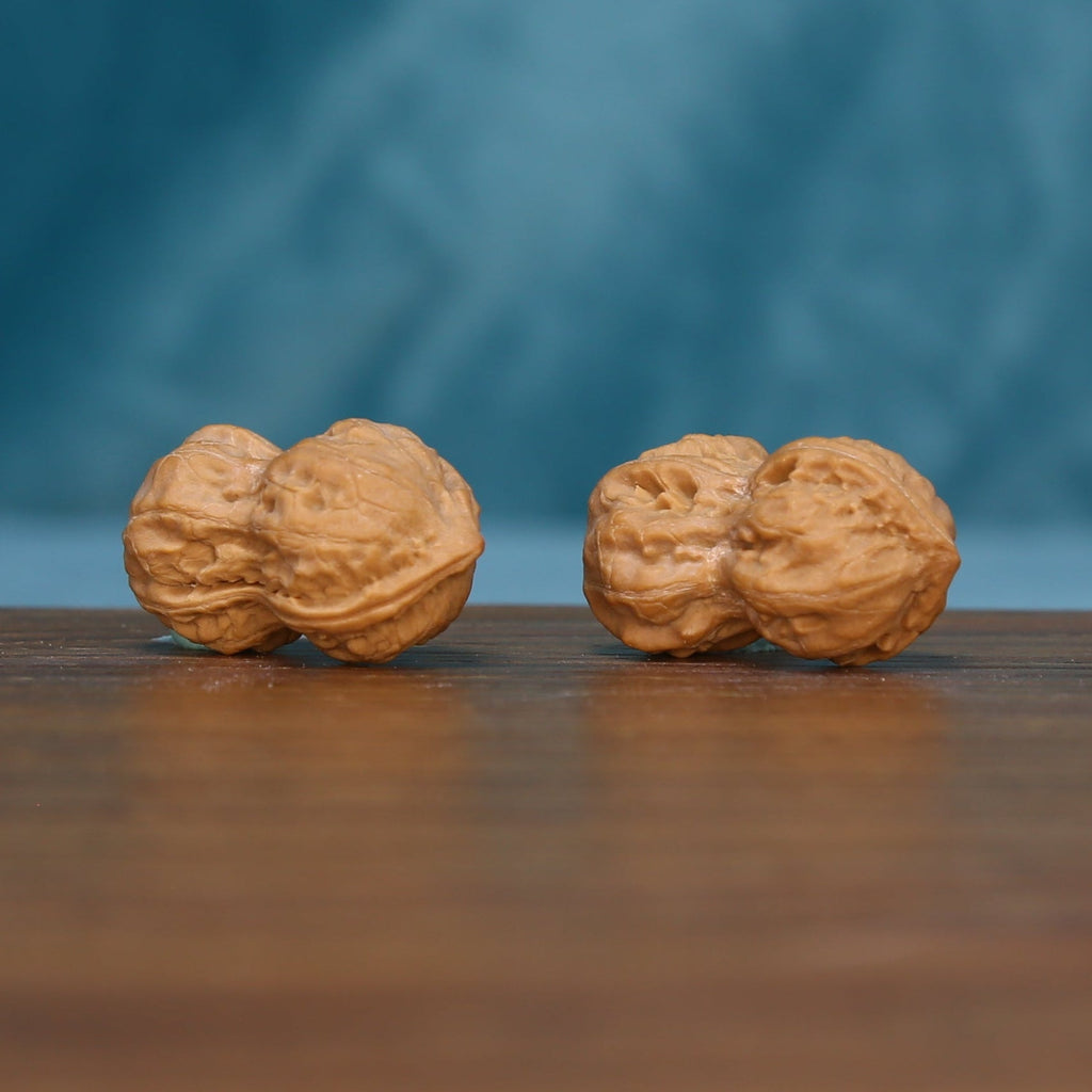 Side view of two L44 Peanut Gourd wenwan walnuts with textured tan surfaces
