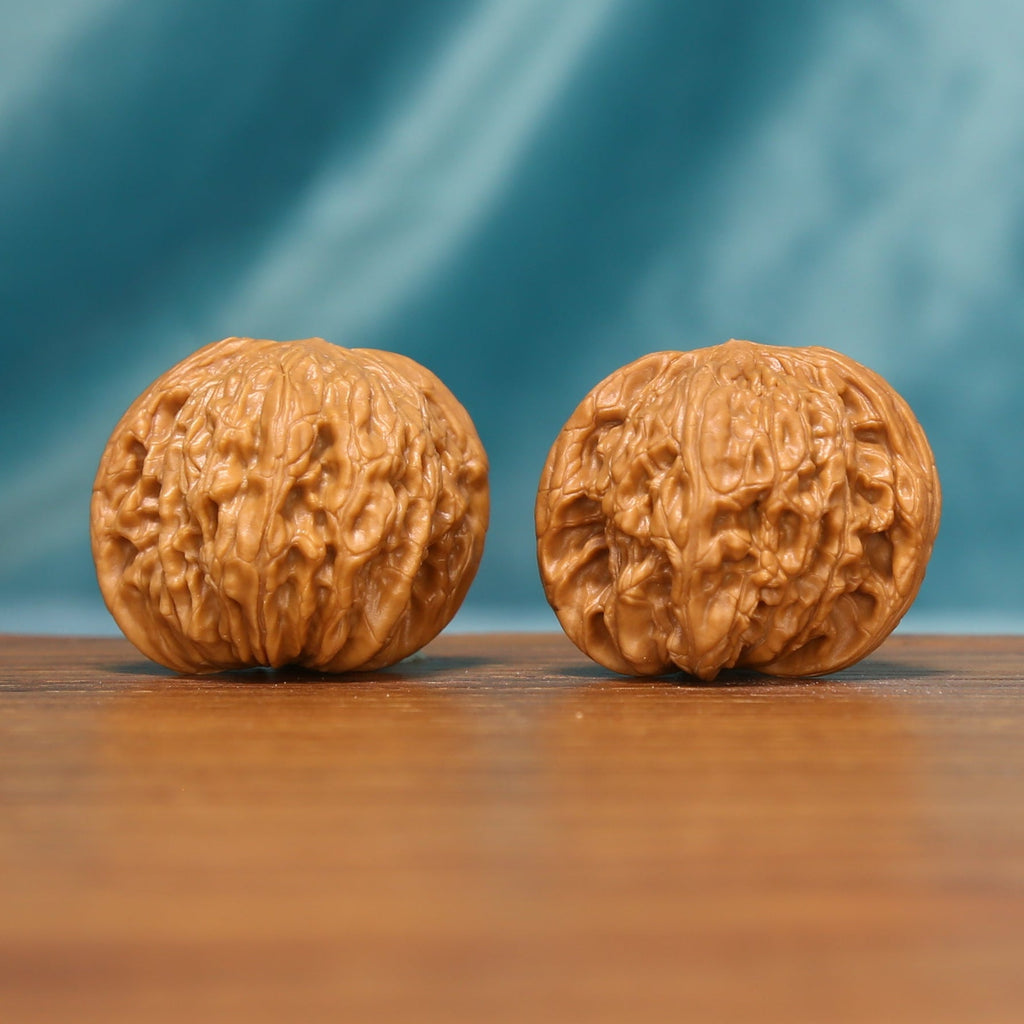 L17 Wenwan walnut matched pair displayed side by side on a wooden surface against a teal background.
