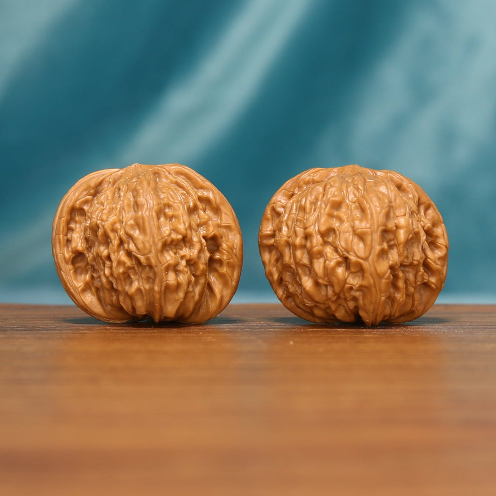 L17 Wenwan walnut pair shown from the front, highlighting rounded forms and natural ridge texture.
