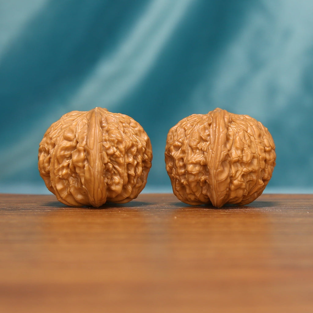 L17 Wenwan walnut matched pair shown from an angled front view, displaying detailed ridges and textured shells.
