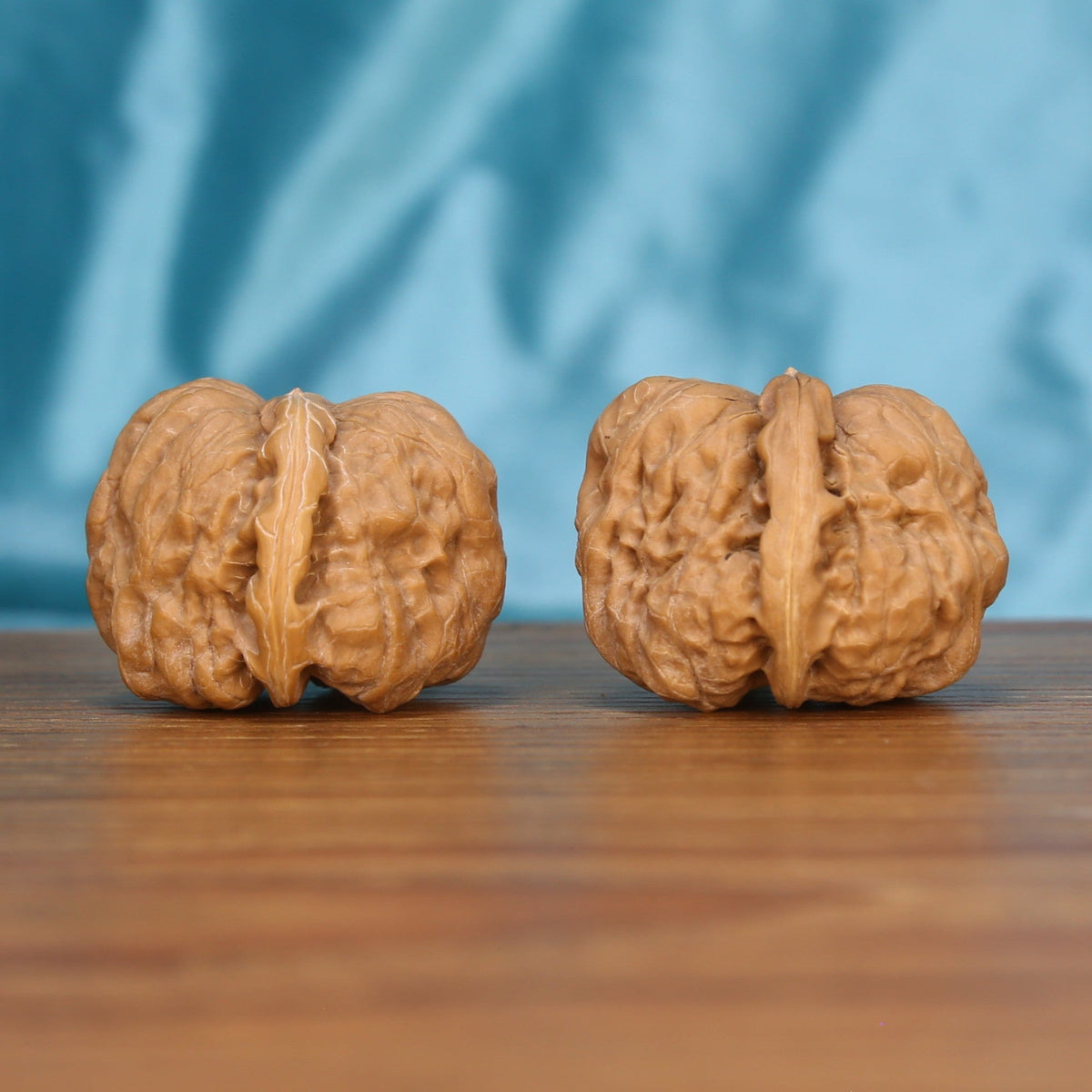 Ha-Ma-Tou wenwan walnut pair alternate angle, blue background – symmetrical rounded ridge pattern