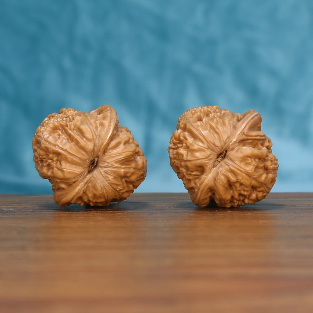 Top view of the Pinggu Ingot wenwan walnut pair 6143, showing the star-shaped ridged crown of each walnut

