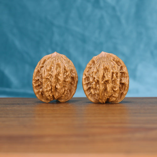 Front view of a matched pair of Wheat Tiger Wenwan walnuts with bold natural ridges

