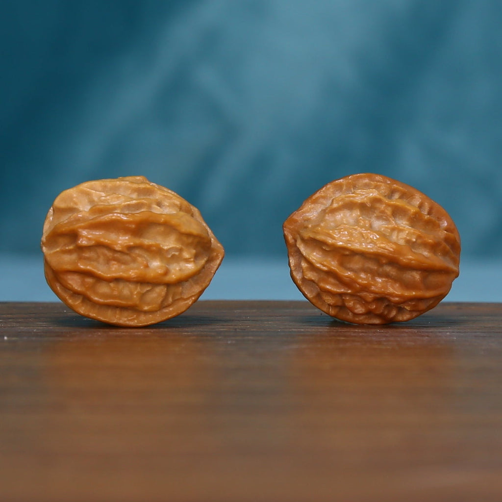 L39 Ember Crest wenwan walnut pair laid on their sides, showing layered ridges
