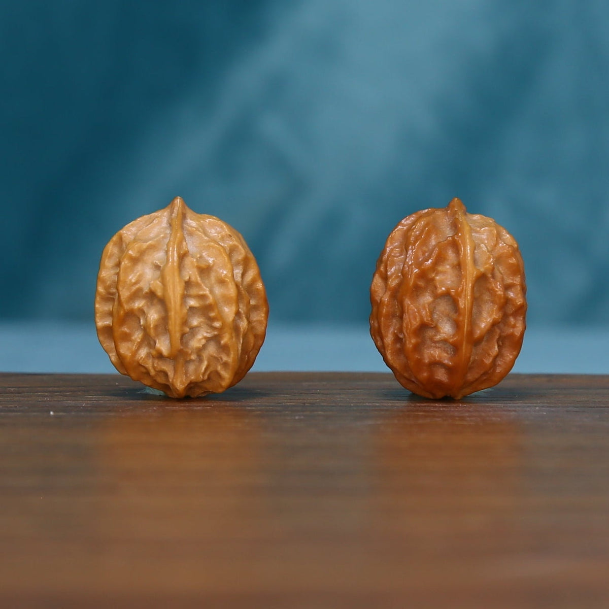 Side view of two L39 Ember Crest wenwan walnuts with warm brown textured surfaces
