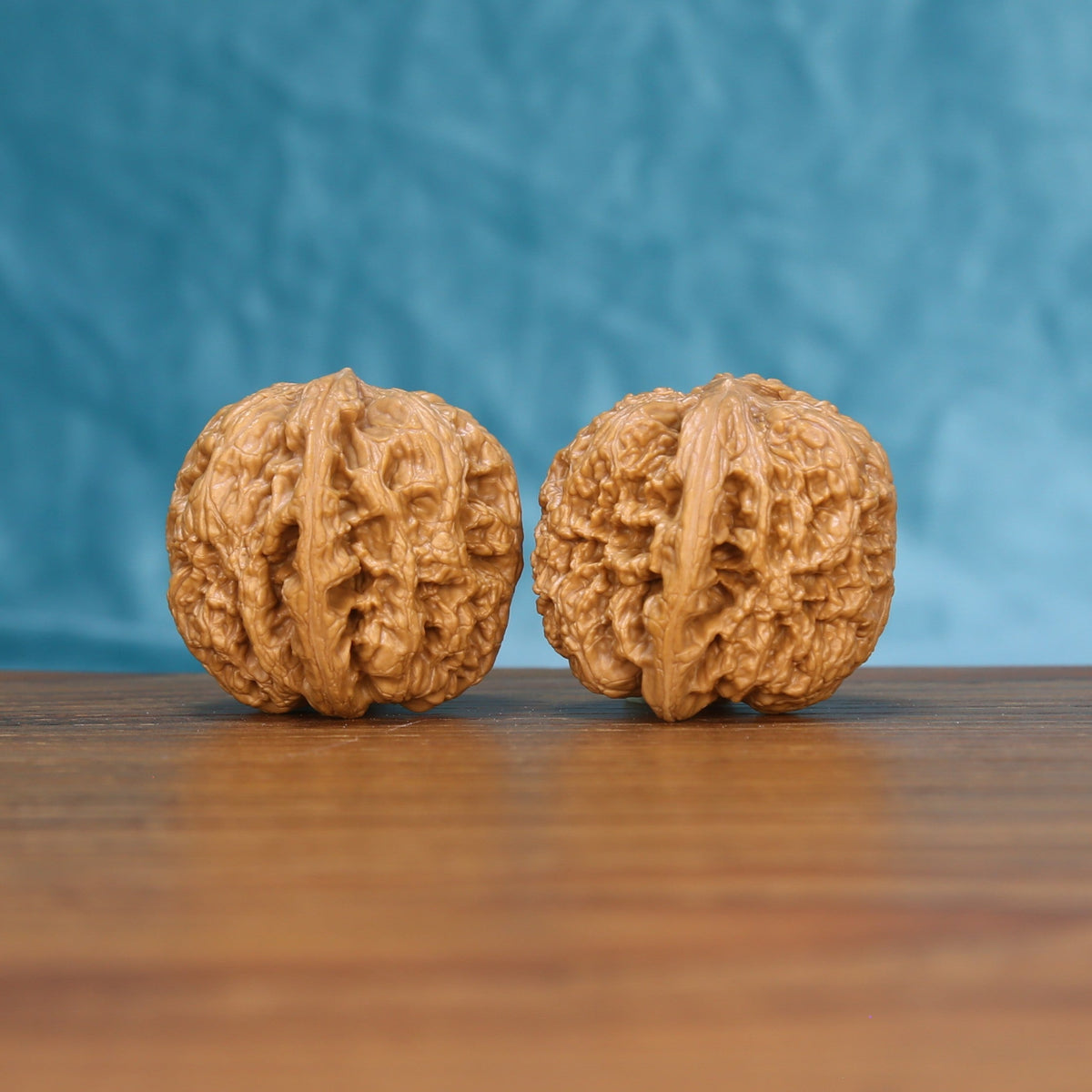 Close view of two matched General wenwan walnuts showing thick carved ridges and warm natural grain
